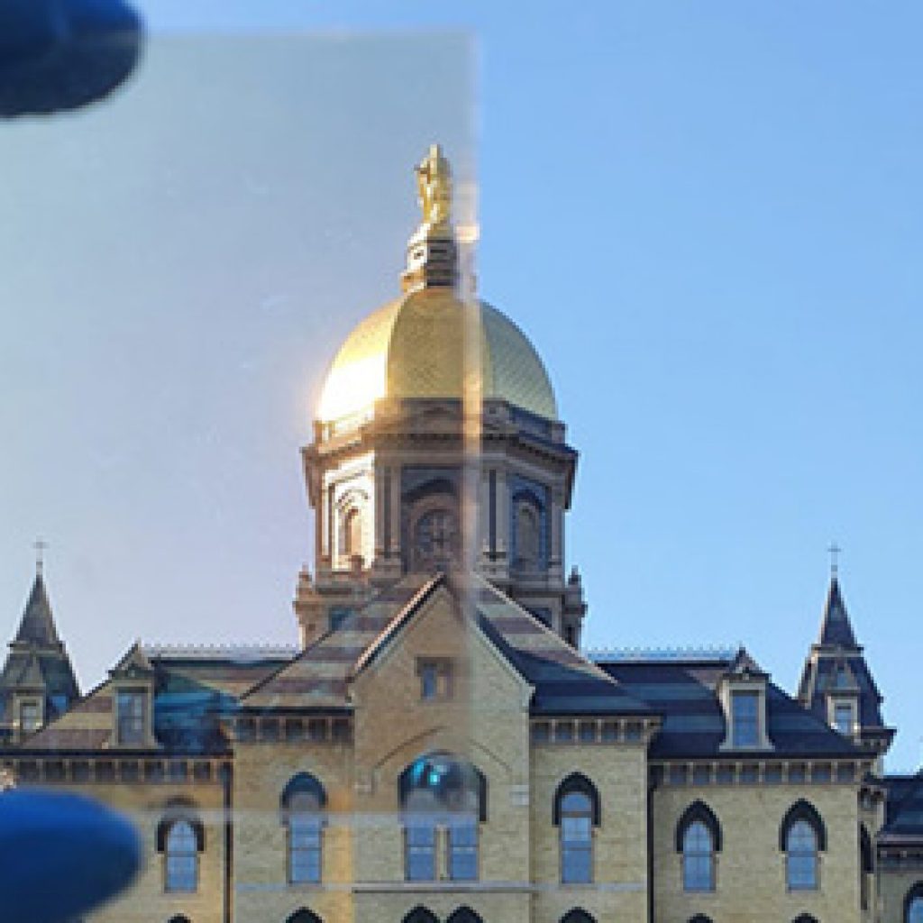 Notre Dame’s Golden Dome partially photographed through a sample (top left) of the TRC window coating.